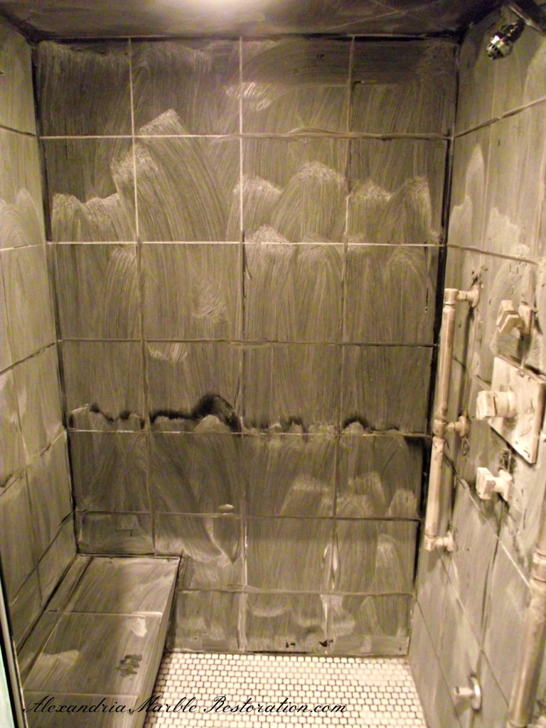 Black marble shower with extreme acid damage