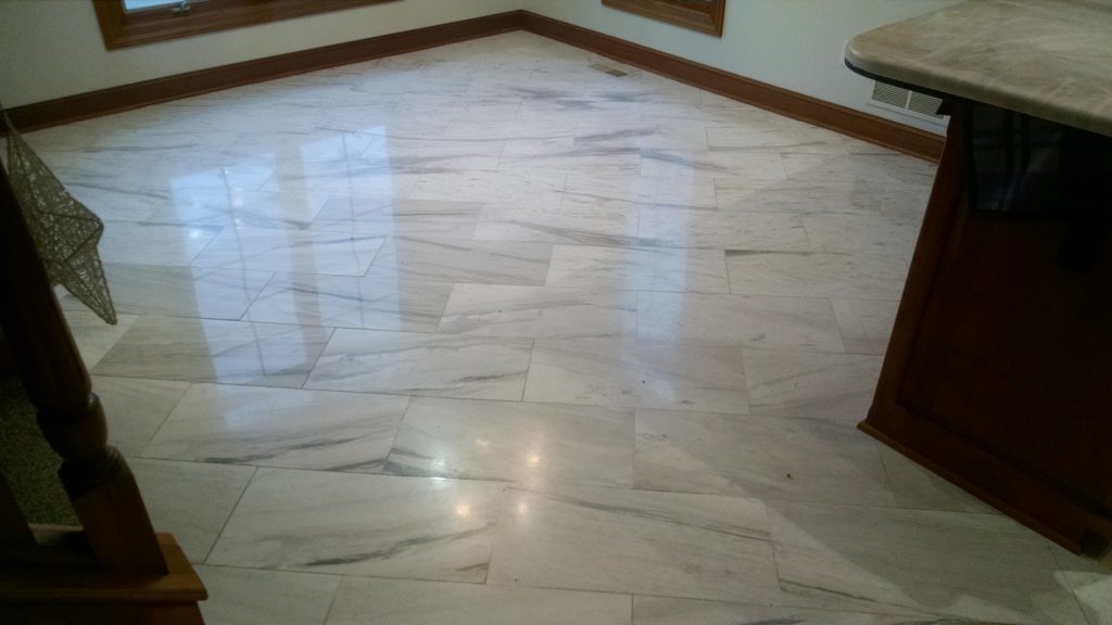 Worn polished finish on white marble flooring