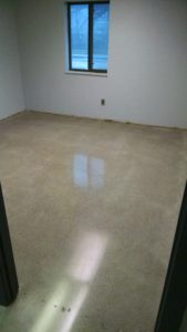 Concrete office floor after removal of carpet glue