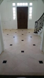 Honed travertine flooring with polished granite inlays