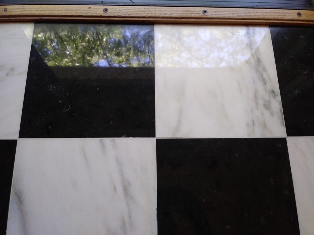 Black and white checkerboard marble foyer flooring after full restoration