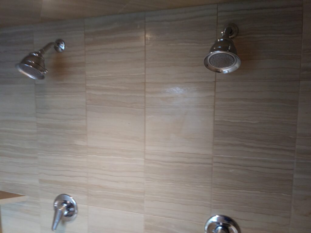 Heavily etched polished marble shower wall before restoration
